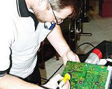 TV repair technician soldering circuit board